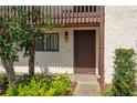 Charming condo entrance with a brown door, lush greenery, and clearly marked unit number at 5102 Village Ct # E-2, Lake Wales, FL 33898