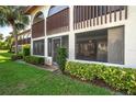 Condo rear exterior view showcasing a screened-in lanai and well-manicured lawn at 5102 Village Ct # E-2, Lake Wales, FL 33898