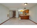 Inviting living room with open layout adjacent to kitchen, light carpet, and tile flooring at 5102 Village Ct # E-2, Lake Wales, FL 33898