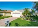 Charming single-story home featuring a well-maintained lawn, brick driveway, and an attached two-car garage at 560 Saint Andrews Rd, Winter Haven, FL 33884