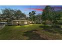 Spacious backyard featuring a well-manicured lawn, shade trees, and a patio area perfect for entertaining at 616 Oriole Dr, Lakeland, FL 33803
