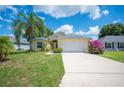 Charming one-story home with palm trees, colorful flowers, and a two-car garage at 630 Heather Glen Loop, Winter Haven, FL 33884