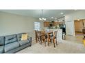 Cozy dining area open to the living room featuring a gray sofa and natural light at 713 Overlook Grove Dr, Winter Haven, FL 33884