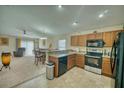 Inviting kitchen featuring wooden cabinets and stainless steel appliances open to the dining and living space at 713 Overlook Grove Dr, Winter Haven, FL 33884