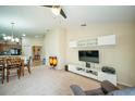 Open-concept living room featuring a ceiling fan, wall decorations, and direct access to the kitchen at 713 Overlook Grove Dr, Winter Haven, FL 33884