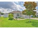 Beautiful single-story home featuring lush green lawn and mature tree in the front yard at 879 Orleans Dr, Eagle Lake, FL 33839