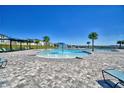 Beautiful community pool area with zero entry splash pad and lounge chairs at 1100 Sugarwood St, Davenport, FL 33837