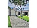 Charming two-story home with a spacious driveway, lush lawn, and mature trees providing shade at 12241 Augusta Woods Cir, Orlando, FL 32824