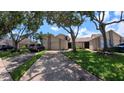 Wide shot of a townhome exterior and driveway, showing mature trees, lush lawn and ample parking at 12241 Augusta Woods Cir, Orlando, FL 32824