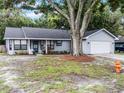 Inviting single-story home with a welcoming front porch and well-maintained landscaping at 125 Homewood Dr, Winter Haven, FL 33880