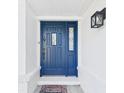 Charming blue front door with decorative glass and brick accents at 14191 Se 25Th Ave, Summerfield, FL 34491