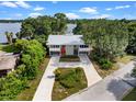Expansive aerial view of modern home with long driveway leading to lake surrounded by mature trees at 1540 N Lake Mirror Nw Dr, Winter Haven, FL 33881
