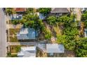 Overhead view displays the property's lot and roof, set among lush trees and neighboring houses at 165 E Pierce St, Lake Alfred, FL 33850