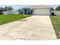 Well-kept home featuring a lush lawn, driveway, and tidy landscaping enhancing its curb appeal and welcome feel at 2018 Misty Morning Dr, Winter Haven, FL 33880