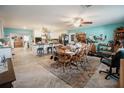 Open living room with wood floors, ceiling fan, and dining area adjacent to the modern white kitchen at 2213 W Pilaklakaha Ave, Auburndale, FL 33823