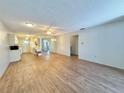Spacious living area with open-concept design, wood floors, ceiling fan, and seamless flow to the kitchen at 254 Winter Ridge Blvd # 254, Winter Haven, FL 33881