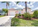 Charming pink home with well-maintained lawn, mature palm trees and tropical landscaping at 263 Reserve Dr, Davenport, FL 33896