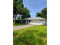 Charming single-story home with a well-manicured lawn, a two-car garage, and mature landscaping at 2909 Pine Tree Dr, Edgewater, FL 32141