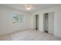 Serene bedroom with tile flooring, natural light, and dual closets for ample storage at 299 Winter Ridge Blvd # 299, Winter Haven, FL 33881