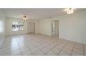 Bright, tiled living room with neutral walls, ceiling fan, and natural light from the front window at 299 Winter Ridge Blvd # 299, Winter Haven, FL 33881