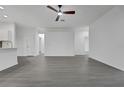 Open floor plan featuring durable grey flooring, a ceiling fan, and a view of the modern kitchen area at 327 Cloverdale Rd, Winter Haven, FL 33884