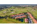 Scenic aerial view of townhomes, a lush golf course, and surrounding greenery, under a clear sky at 351 Enclave Dr # 94, Lakeland, FL 33803