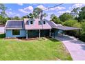 Charming single-Gathering home featuring a covered carport, solar panels, and a well-manicured lawn at 3705 Pine Cir, Lake Wales, FL 33898