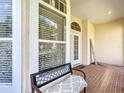 Cozy front porch featuring tiled floors, decorative windows, and a bench at 380 Niblick Cir, Winter Haven, FL 33881