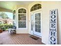 Inviting front porch with brick flooring and charming decor at 380 Niblick Cir, Winter Haven, FL 33881