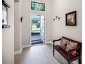 Inviting entryway featuring light wood floors, a decorative bench, and a stained glass window at 4100 Martindale Loop, Winter Haven, FL 33884
