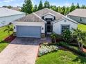 Charming single-story home with a two-car garage, brick paved driveway and manicured landscaping at 4100 Martindale Loop, Winter Haven, FL 33884