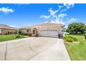 Lovely single-Gathering home with a two-car garage, lush green lawn, and mature landscaping, creating a welcoming curb appeal at 413 Ruby Lake Pl, Winter Haven, FL 33884