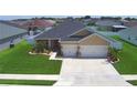 Lovely single-story home with a two-car garage, surrounded by well-maintained landscaping and a lush lawn at 421 Riders Loop, Auburndale, FL 33823