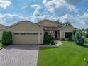 Charming one-story home featuring well-manicured lawn, brick driveway, and a cozy, inviting entrance at 4356 Ashton Club Dr, Lake Wales, FL 33859