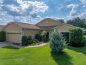 One-story home featuring well-manicured lawn, lush landscaping, and a brick driveway at 4356 Ashton Club Dr, Lake Wales, FL 33859