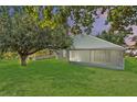 Spacious backyard featuring a screened-in lanai, lush lawn, and mature trees at 436 China Berry Cir, Davenport, FL 33837