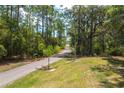 Long paved driveway leading to the property, lined with trees and landscaping at 4949 Lake Kotsa Dr, Lake Wales, FL 33898