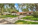 Well-maintained home with mature trees, landscaped yard, and long driveway at 527 Duchess Dr, Lakeland, FL 33803