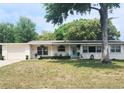 Charming single-story home with a well-kept lawn and a pop of color from the bright blue front door at 550 E Thelma St, Lake Alfred, FL 33850