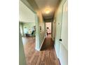 Hallway with wood floors leading to bedroom and living area, showcasing the home's layout at 550 E Thelma St, Lake Alfred, FL 33850