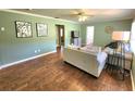 Cozy living room features fresh paint, wooden floors, ceiling fan, and comfortable seating for relaxation at 550 E Thelma St, Lake Alfred, FL 33850