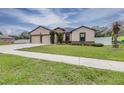 Inviting home featuring a two-car garage, neutral paint, stone accents, and a well-maintained lawn at 607 S 16Th St, Haines City, FL 33844