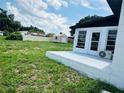 Spacious backyard with a small patio, a storage shed, and a privacy fence, perfect for outdoor activities and relaxation at 655 E Sanford St, Lake Alfred, FL 33850