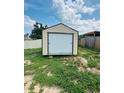 Exterior view of a storage shed in the backyard, providing ample storage space for tools and equipment on a grassy lot at 655 E Sanford St, Lake Alfred, FL 33850