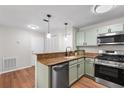 Galley kitchen featuring granite countertops, stainless steel appliances, and wood floors at 703 Magnolia Pl # 703, Winter Haven, FL 33884
