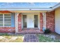 Close up of the front porch with brick columns, decorative ironwork, and a tiled walkway at 961 Piedmont Se Dr, Winter Haven, FL 33880