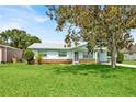 Quaint single-story house with a spacious front lawn and mature shade tree at 109 Dakota Ave, St Cloud, FL 34769
