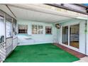 Enclosed patio with green carpet flooring, windows, and sliding glass doors at 109 Dakota Ave, St Cloud, FL 34769