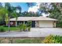 Charming home with metal roof, stone accents, and manicured landscaping, including roses at 1273 Scrub Jay Trl, Frostproof, FL 33843