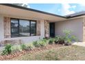Inviting front entrance with decorative shutters, stone accents, and lush landscaping at 1334 Highland Park S Dr, Lake Wales, FL 33898